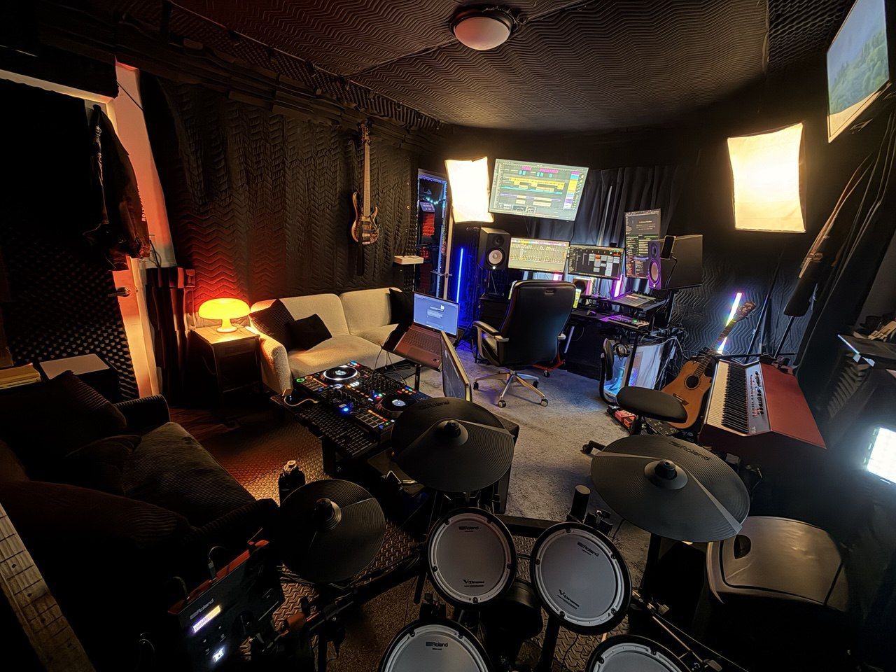 Roland V-Drums view looking toward DAW desk — couch, mushroom lamp, softbox lights